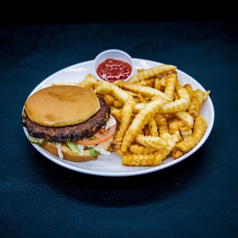 A You Gotta Eat Here! burger with lettuce and tomato, served with crinkle-cut fries and ketchup.
